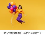 Full body side view happy fun young woman wearing casual clothes celebrating hold bunch of balloons look aside on area jump high isolated on plain yellow background Birthday 8 14 holiday party concept