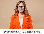Close up young fun happy successful employee business woman corporate lawyer 30s wearing classic formal orange suit glasses work in office look camera isolated on plain beige color background studio