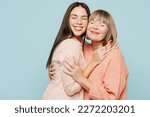 Adorable lovely fun satisfied elder parent mom with young adult daughter two women together wearing casual clothes hugging cuddle close eyes isolated on plain blue cyan background. Family day concept