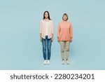 Full body smiling happy fun cheerful cool confident elder parent mom with young adult daughter two women together wear casual clothes look camera isolated on plain blue background. Family day concept