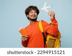 Small photo of Traveler young teen boy student man wear casual clothes backpack bag hold passport ticket mock up of plane isolated on plain blue background. Tourist travel abroad to study. Air flight trip concept