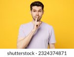 Small photo of Young secret caucasian man he wearing light purple t-shirt casual clothes saying hush be quiet with finger on lips shhh gesture isolated on plain yellow background studio portrait. Lifestyle concept