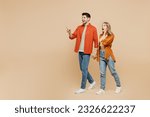 Small photo of Full body young couple two friends family man woman wear casual clothes together point index finger aside indicate on workspace area copy space mock up isolated on pastel plain beige color background