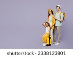 Small photo of Traveler parents mom dad with child girl wear casual clothes hold bags point aside isolated on plain purple background. Tourist travel abroad in free time rest getaway. Air flight trip journey concept