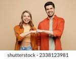 Small photo of Young smiling happy buddies fun couple two friends family man woman wear casual clothes looking camera giving fist bumo together isolated on pastel plain light beige color background studio portrait