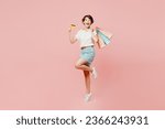 Small photo of Full body happy surprised shocked young woman wear casual clothes hold shopping paper package bags credit bank card isolated on plain pink color background studio. Black Friday sale buy day concept