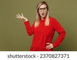 Small photo of Young shocked confused indignant sad mad displeased woman she wear red shirt casual clothes glasses look camera spread hand isolated on plain pastel green background studio portrait. Lifestyle concept