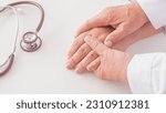 Small photo of doctor's hand holding calms reassuring the patient's hospital. close-up the encouragement trust and medical lessening support carefully. Hands resting on the table with a stethoscope near the doctor.