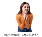 Small photo of A studio portrait of a young Asian Indonesian woman wearing an orange long-sleeve shirt looks happy as she smiles while her hands are clasped in front of her chest. Isolated on a white background.