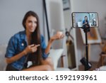 Blogger of caucasian woman with review product and talking camera live recording video on social network at home. Online merchants selling cosmetics on social media via mobile phones.