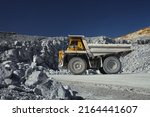 Heavy mining dump truck, close-up, takes out up the stone rock mined in a limestone quarry.