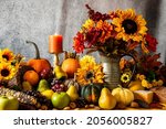 Small photo of Thanksgiving cornucopia with pumpkins fruit flowers and burning candle