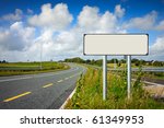 road with sign pole and blue sky with clouds