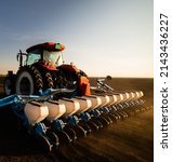Small photo of Farmer with tractor seeding - sowing crops at agricultural field. Plants, wheat.