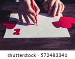 Dos cors royalty free images.Woman writes love letter on white paper with red heart shape figures.Hand made postcard for Saint Valentines Day celebration.Send love letter on 14th of February