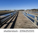 Small photo of The long wooden pier looking inwards at at Murrell's Inlet, south of Myrtle Beach, South Carolina, USA, on a sunny day with blue sky.