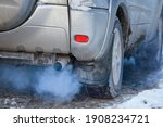 Small photo of Close-up of car smoking exhaust pipe, car with gasoline engine. Gasoline engine warming up at idle in winter season. Blue exhaust smoke