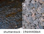 Small photo of Gabion wall constructed using steel wire mesh basket. Stone walls, gabion revetment - protection from backshore erosion. Gabion and rock armour - coastal and waterways protection.