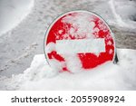 Do not enter road sign. Car traffic prohibited. Warning no entry zone. Drive in forbidden. No entry - road sign during snowfall, covered with snow