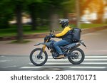 Small photo of Food delivery motor bike driver with backpack behind back is on his way to deliver food. Courier on motorcycle delivering food. MOTION BLUR. Shipping of goods to customers from restaurant. Takeaway