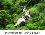 Adult Tourist Wearing Casual Clothing On Zip Line Trip Selective Focus Against Blurred Forest