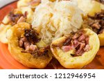 Potato dumplings stuffed with smoked meat sprinkled with fried onion with pickled white cabbage, traditional Czech meal. Closeup.
