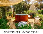 Small photo of Outdoor relaxation area surrounded by lush vegetation in sunny day. A luxurious spa with a relax zone and tents in the form of wigwams. Location place Croatia, Europe. Discover the beauty of earth.