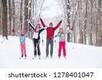 Family with two children cross-country skiing in the winter forest in the snow