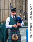 Small photo of EDINBURGH, UK - JUNE 11, 2022: Bagpiper playing music with bagpipe near Edinburgh Castle in Edinburgh, Scotland, UK
