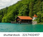 Old wooden dock houses on the lake with typical wooden pier, the Walchensee in Bavaria Germany