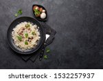 Delicious mushrooms risotto dressed with parmesan cheese and parsley. Top view with copy space for your text