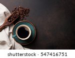 Coffee cup and beans on old kitchen table. Top view with copyspace for your text