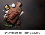 Grilled ribeye beef steak, herbs and spices. Top view with copy space for your text