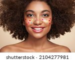 Small photo of Beauty portrait of African American girl with afro hair. Beautiful black woman. A Womans face decorated with decorative hearts. Valentines day photo