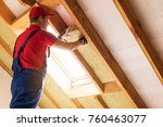 house attic insulation - construction worker installing rock wool in mansard wall