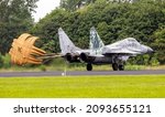 Small photo of Slovak Air Force Mig-29 Fulcrum fighter jet landing with brake parachute on Leeuwarden Air Base. June 10, 2016