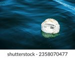 Small photo of A soccer leather ball floats on the sea. A soccer ball floats on the sea. Football without borders, sport reaches the wildest places concept