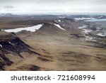 Ancient glacial trough. Ablation zone of modern shrinking glacier, moraine boundary (lateral moraine), rotted rocks, stratification of deposits. Novaya Zemlya Arch. North Island. View from helicopter