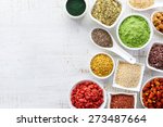 White bowls of various superfoods on white wooden  background