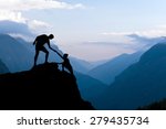 Teamwork couple helping hand trust assistance silhouette in mountains, sunset. Team of climbers man and woman hiker, help each other on top of mountain, beautiful landscape in Himalayas Nepal