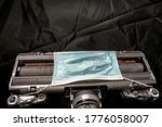 Small photo of Disposable face mask strapped to bottom of vacuum cleaner, for concepts of air quality, disease transmission, public health and stopgap measures