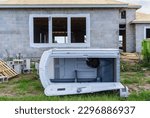Small photo of Vacant portable toilet fallen in front of a single-family house under construction in a suburban development in southwest Florida, for motifs of wind or accident, deterioration, mischief