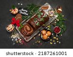 Chocolate yule log on dark background. Traditional dessert of Christmas time. Top view, copy space