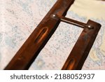 Small photo of Vintage wooden parallel ruler lays on a nautical paper chart. It is a drafting instrument used by navigators to draw parallel lines on charts
