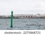 Small photo of Port hand green spar buoy with light on top. Navigation equipment of Reykjavik harbor, Iceland