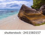 Beau Vallon beach, Seychelles. Coastal view with white sand and wet stone in shape the shape of a head of a sperm whale 