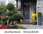 Front door to a Canadian house decorated with Halloween pumpkins.