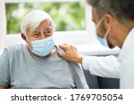 Doctor Talking To Elderly Patient At Home