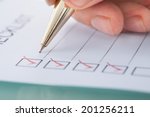 Cropped image of businessman preparing checklist at office desk