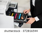 Midsection of young businessman fixing cartridge in printer machine at office